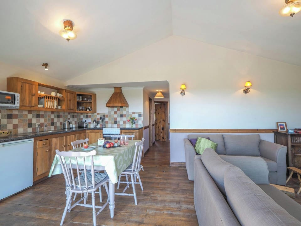 Kitchen and dining area with table and chairs, living area with sofas