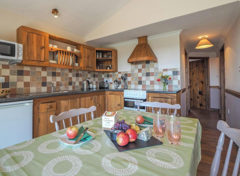 Kitchen and dining area, wooden kitchen units, cooker and cooker hood, dining table
