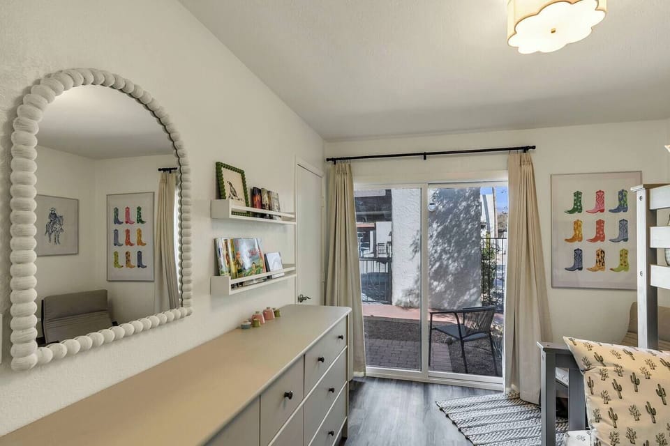 Kids bedroom with books, toys, and mirror.