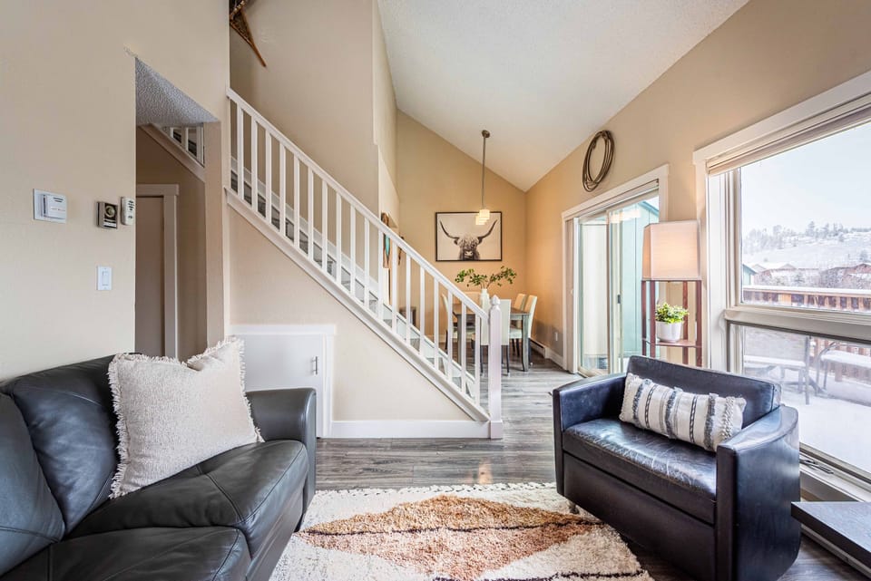 Open-concept living and dining area with fireplace, smart TV, and private deck