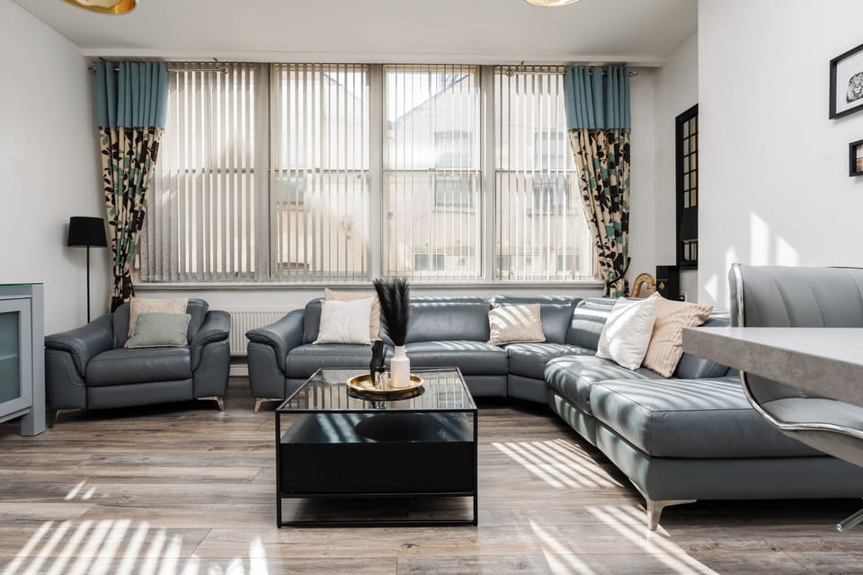 The comfortable living space features a large open-plan lounge and kitchen, Smart TV with Netflix, and spacious seating—ideal for relaxing after a day in the city.
