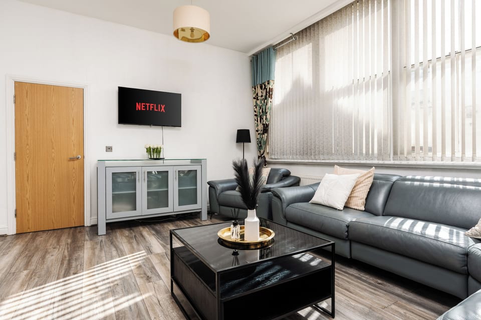 The comfortable living space features a large open-plan lounge and kitchen, Smart TV with Netflix, and spacious seating—ideal for relaxing after a day in the city.
