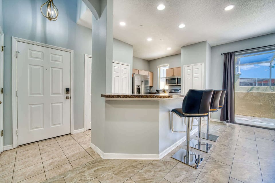 Modern kitchen with breakfast bar seating and natural light from sliding glass doors