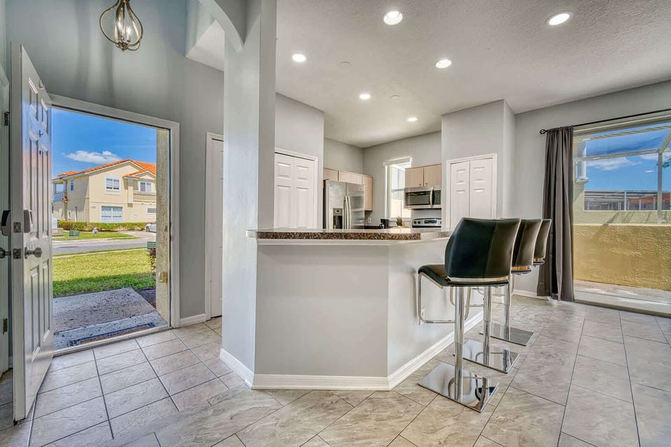 Modern kitchen with breakfast bar seating and natural light from sliding glass doors