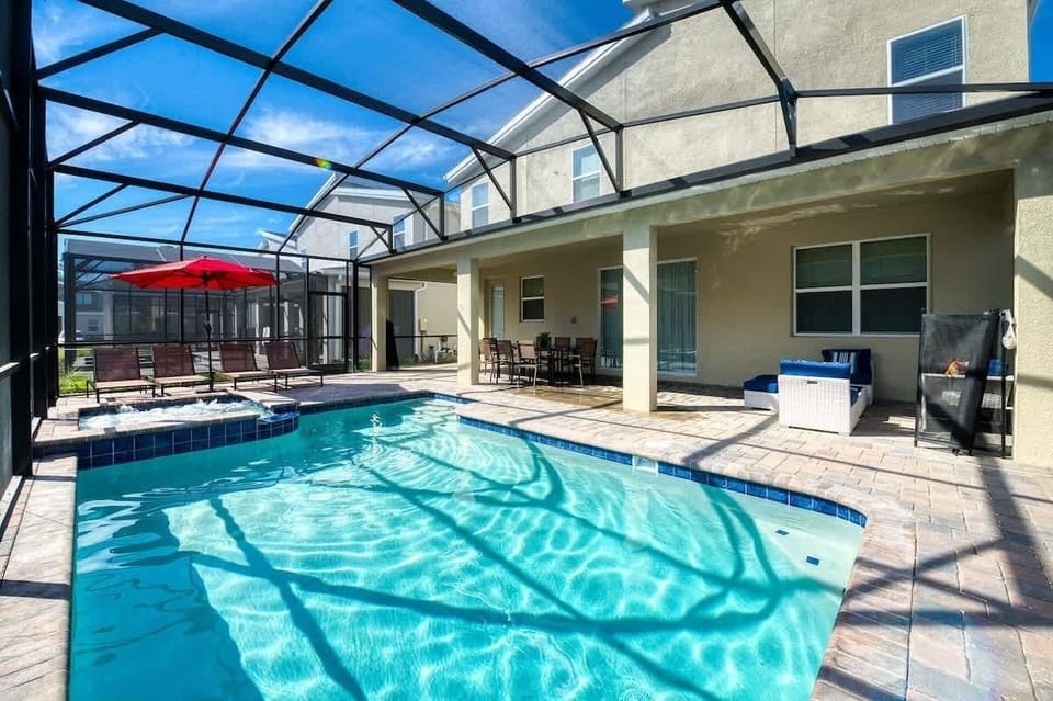 Private screened pool with spa, loungers, and shaded outdoor dining area.