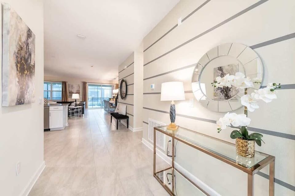 Elegant entryway with modern décor, sleek tile floors, and open-concept living ahead.