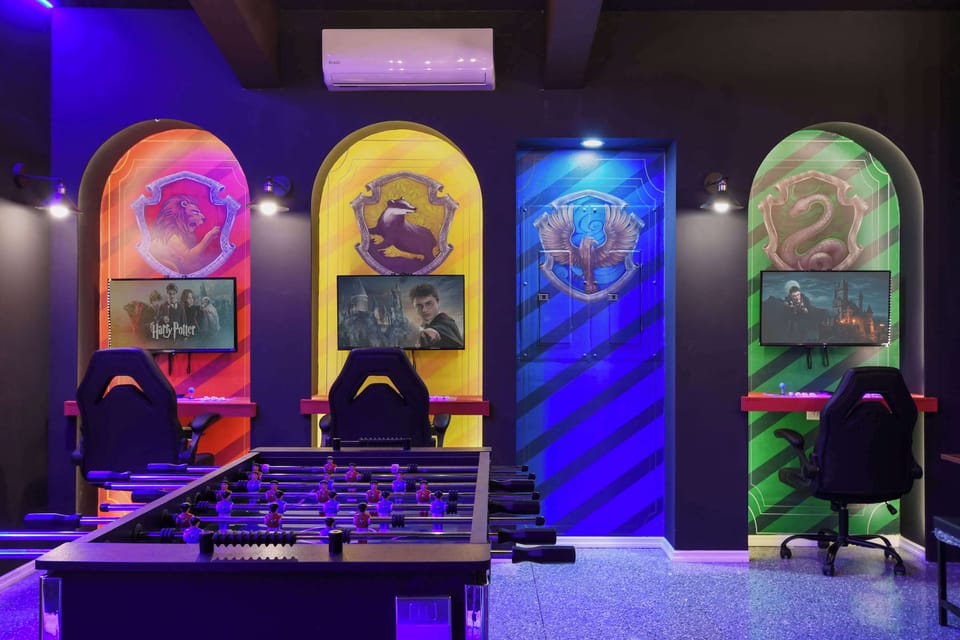 Wizarding World game room with house-themed gaming stations & foosball!