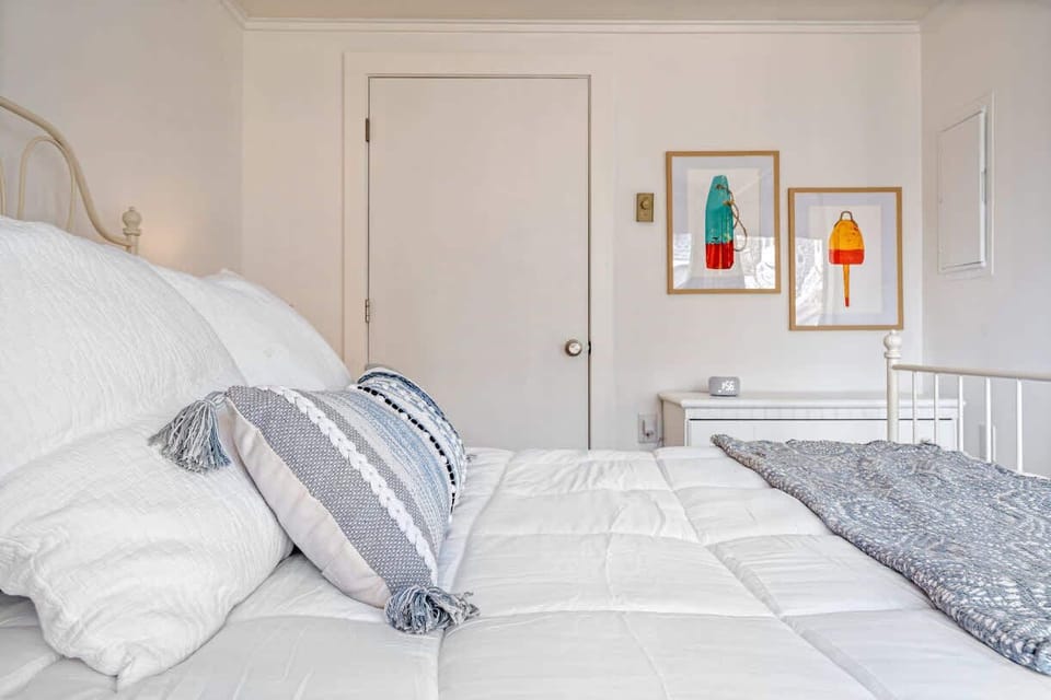 The serene bedroom area boasts a plush queen bed & balcony access