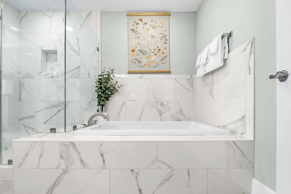 Slide into the tub and let veined tile and ambient lighting soothe you in this elegant master bath