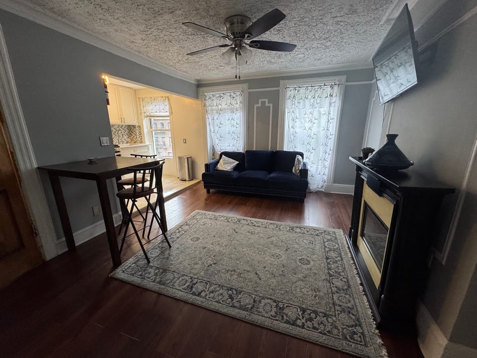 Living room with smart TV, dining table, and fireplace
