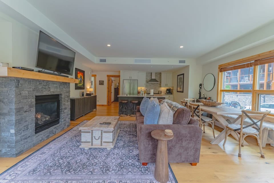 Living room with fireplace, sofa, and dining area