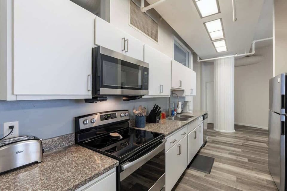 - Fully equipped kitchen with stainless appliances and ample prep space 
- Long countertop ideal for meal prep and cooking during your stay 
- Modern apartment kitchen perfect for extended and short stays 