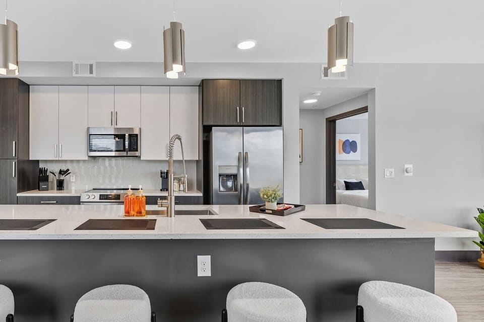 - Sleek  shared  kitchen with island seating and bright modern finishes  
- Stainless appliances ready for easy everyday cooking  
- Open layout creating a social inviting atmosphere  