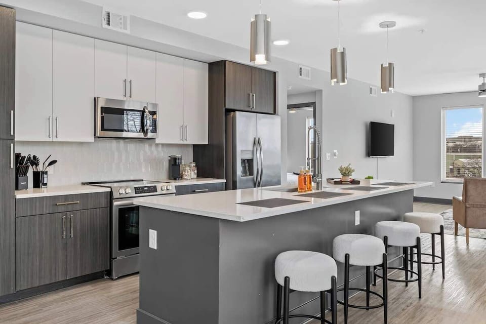 - Modern  shared  kitchen with island seating and sleek appliances for easy prep  
- Bright layout connecting dining and living areas  
- Contemporary design offering comfort and style