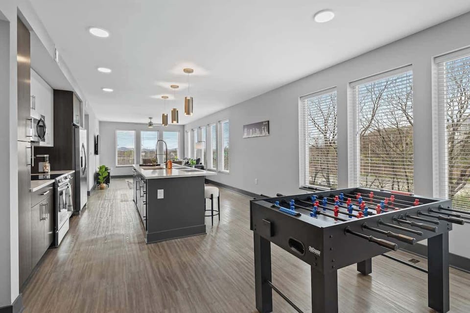 - Open kitchen and foosball space designed for group fun  
- Spacious layout ideal for cooking, bonding, and entertaining  
- Bright windows filling the area with natural inviting light  