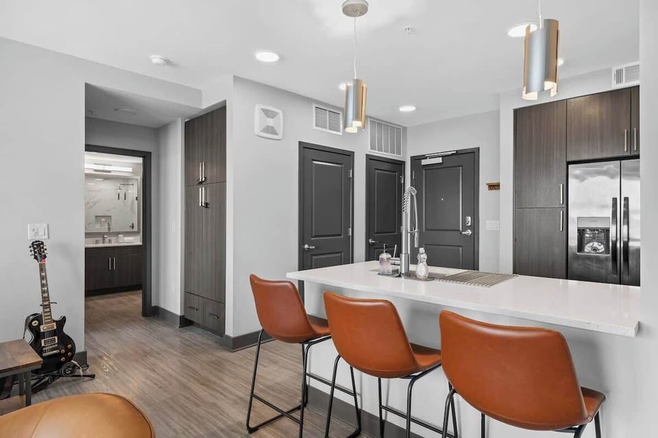 - Shared Kitchen island with stylish barstools and open layout  
- Bright space designed for easy meals and gathering  
- Modern rental offering comfort and convenience  
