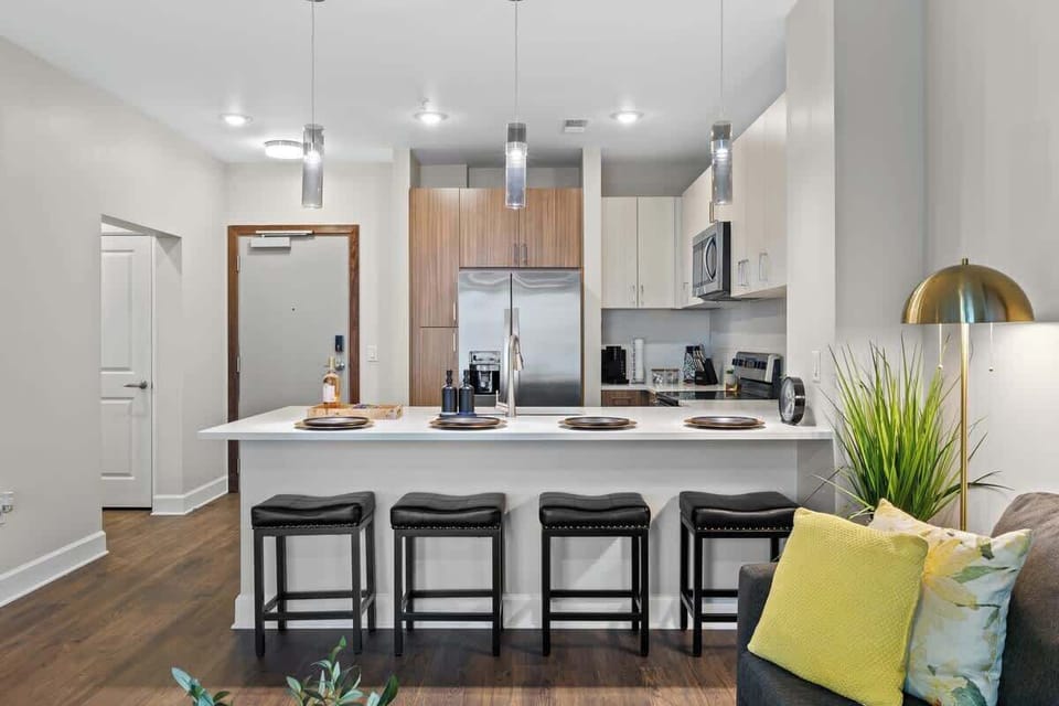 - Modern shared kitchen with spacious island seating perfect for guest gatherings  
- Stainless appliances ideal for easy meal prep during short term rental stays  
- Bright open design connecting to living area for relaxed comfort  
