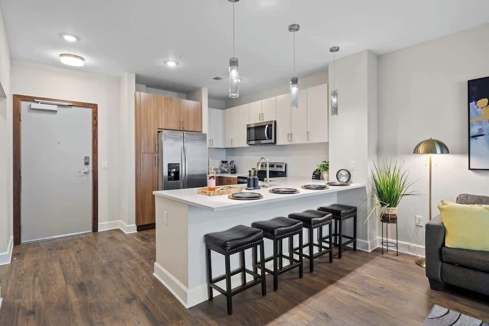 - Sleek shared kitchen with stainless appliances and spacious island seating for guests  
- Pendant lighting highlights this modern cooking space perfect for extended stays  
- Fully equipped short term rental kitchen designed for easy meal prep  
