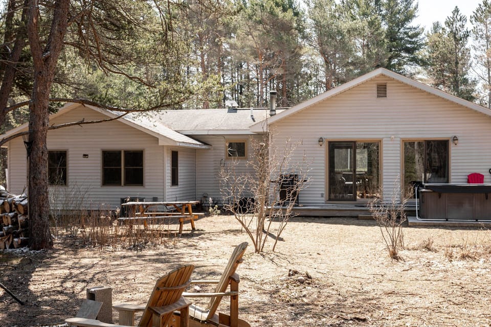 Sunlit backyard w/ picnic table, hot tub & space to gather beneath the trees.