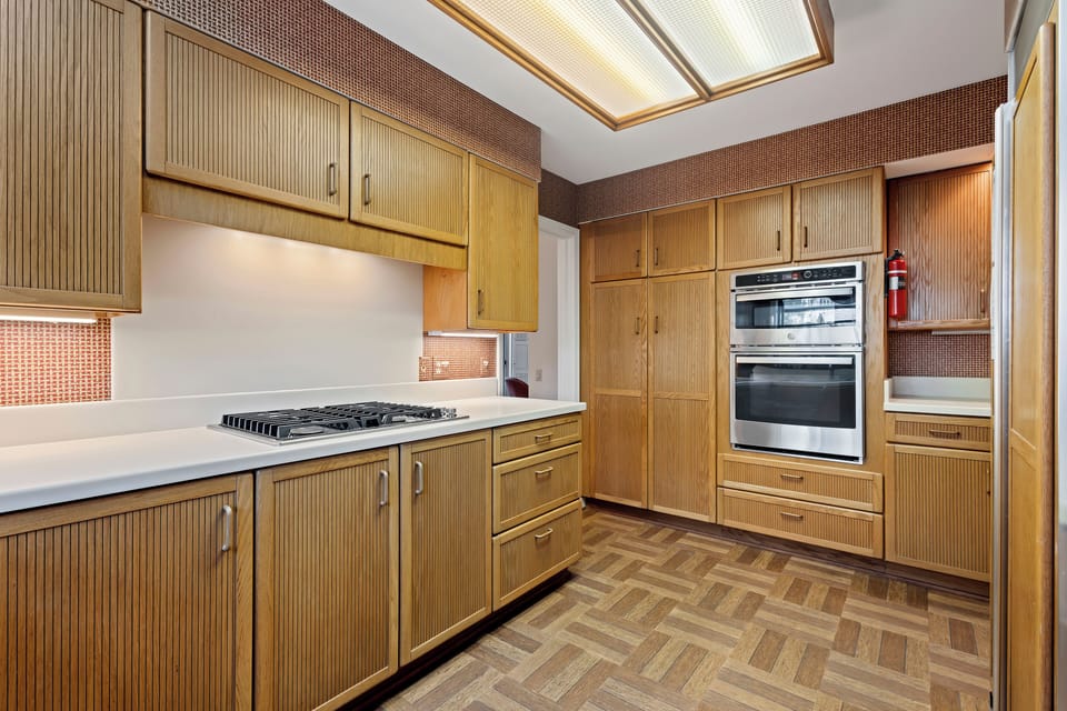 Modern kitchen with stainless steel appliances and double oven.