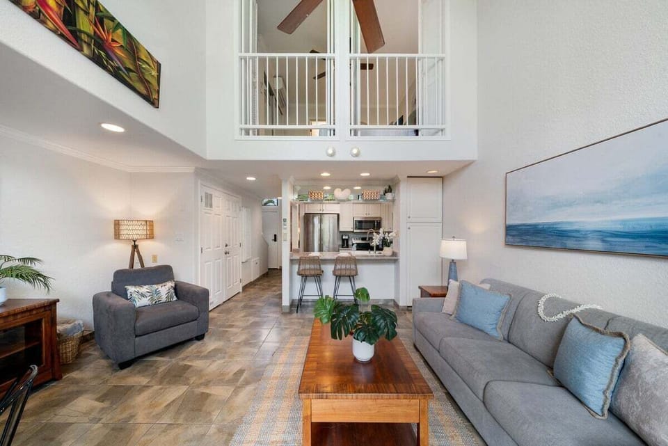 Spacious living room with soaring ceilings, cozy seating, and natural light.