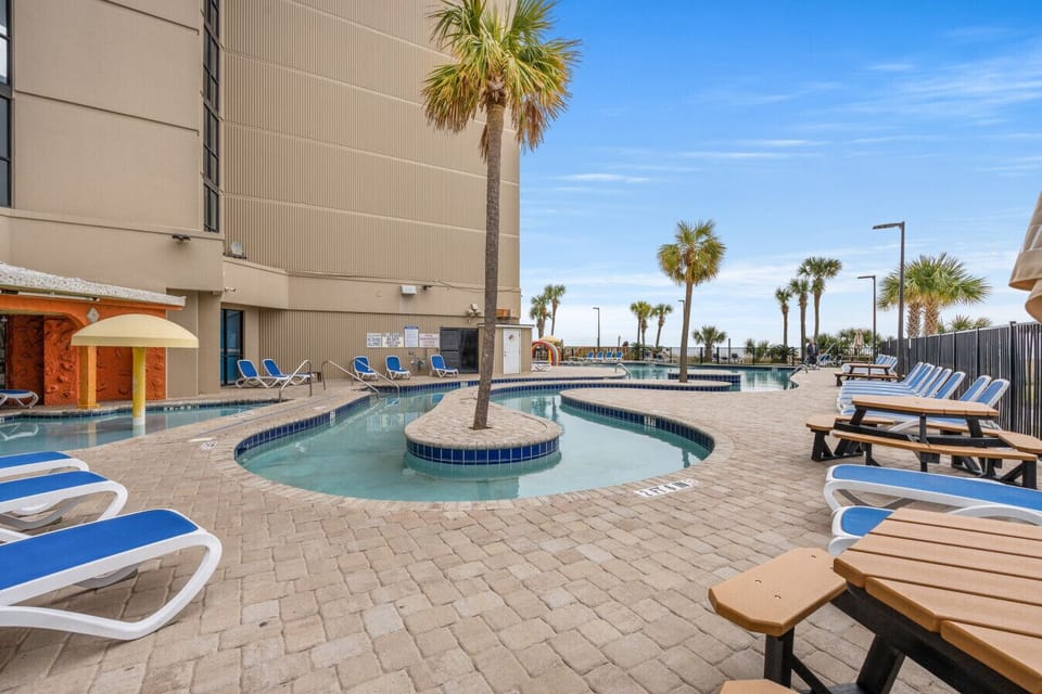 Resort amenities include outdoor pools (seasonally heated) and relaxing hot tubs, perfect for soaking up the sun or unwinding after a beach day in a beautifully maintained setting.