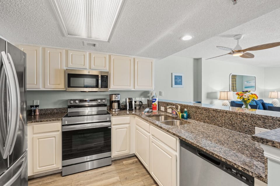 Fully equipped kitchen with stainless steel appliances including refrigerator, dishwasher, stove, oven, and microwave. Stocked with cookware, dishware, silverware, coffee makers, and toaster—perfect for easy meals.