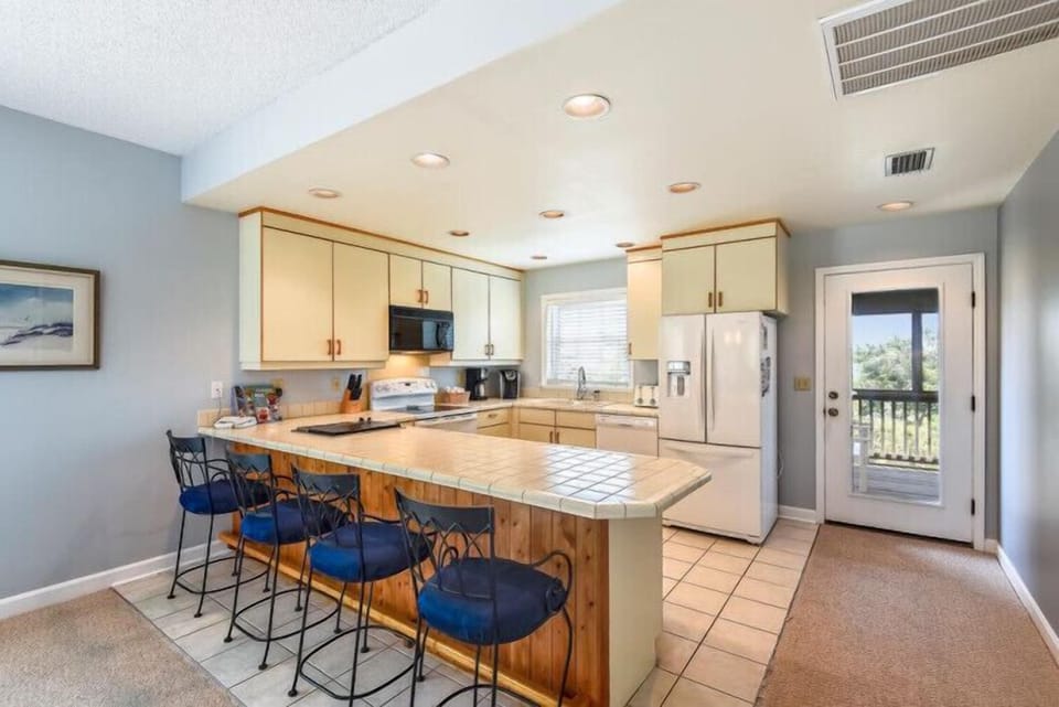 Gather around your spacious kitchen island with seating for six. Enjoy cooking with modern appliances and ample counter space as natural light fills the room.