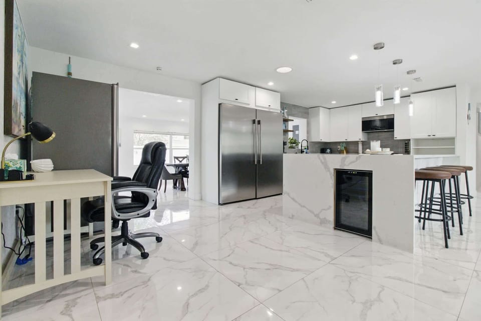 This well-equipped kitchen features a full-size refrigerator, perfect for storing groceries during longer stays, along with plenty of counter space for meal prep. A convenient side workspace offers extra room for working remotely.