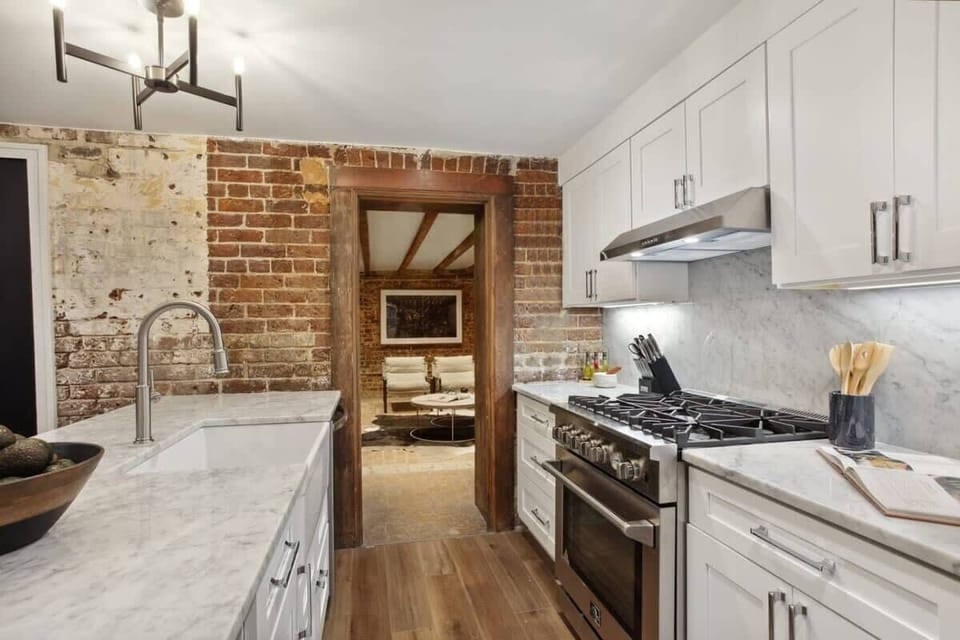 Kitchen Unit 1 | Fully Stocked Kitchen with Brick Wall and Natural Light | Unit 1 — Garden Level — Unit on One Level