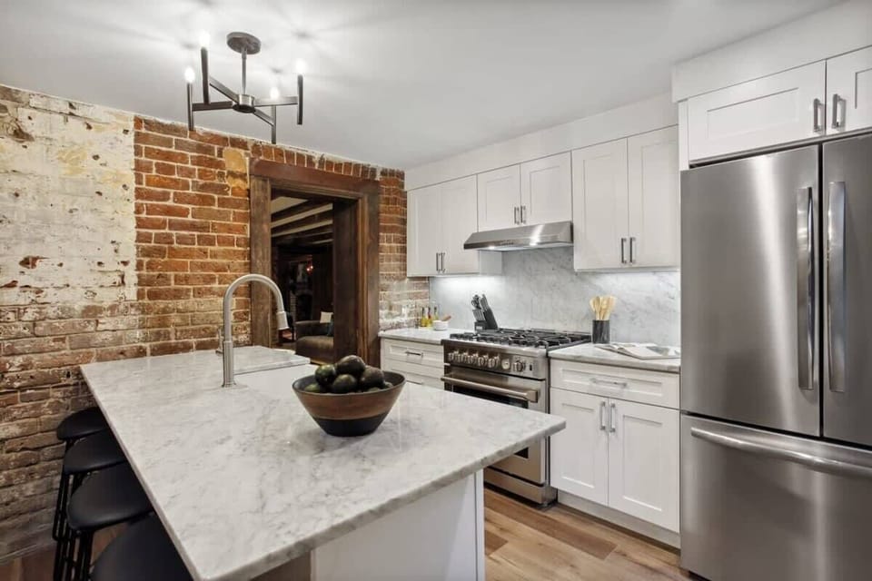 Kitchen Unit 1 | Fully Stocked Kitchen with Brick Wall and Natural Light | Unit 1 — Garden Level — Unit on One Level