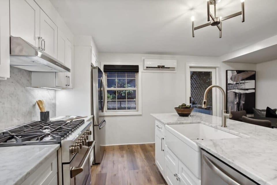 Kitchen Unit 1 | Fully Stocked Kitchen with Brick Wall and Natural Light | Unit 1 — Garden Level — Unit on One Level