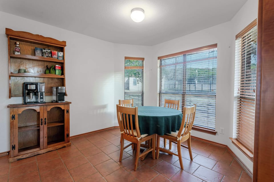Cozy breakfast nook with a wooden dining set, perfect for morning coffee while enjoying views through large windows.