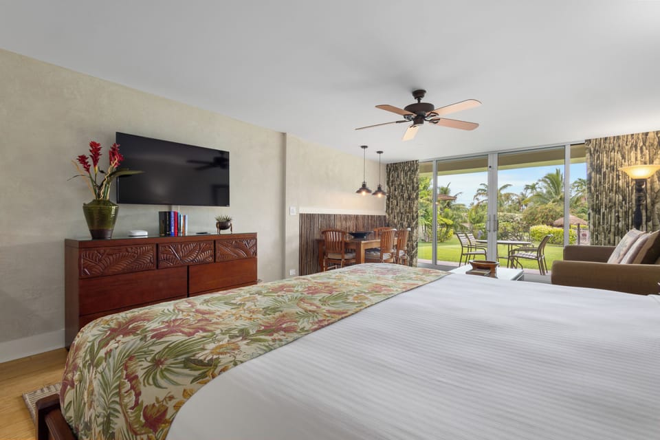 Your tropical retreat features a king bed with island-style linens, a flat-screen TV, and private access to lush garden views and your outdoor patio seating.