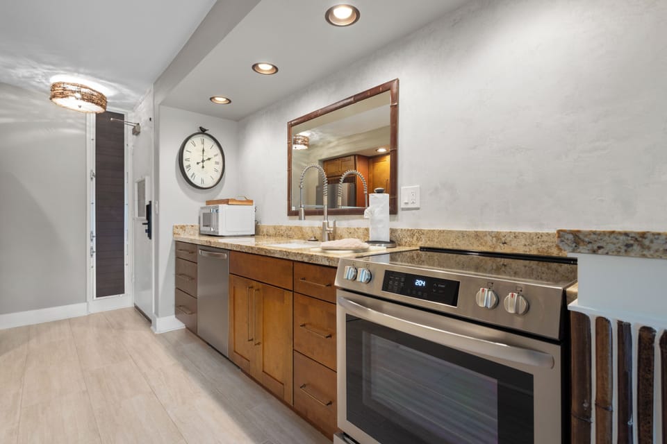 Your fully equipped kitchen boasts sleek granite countertops, stainless steel appliances, and warm wood cabinetry—perfect for preparing meals in comfort and style during your stay.