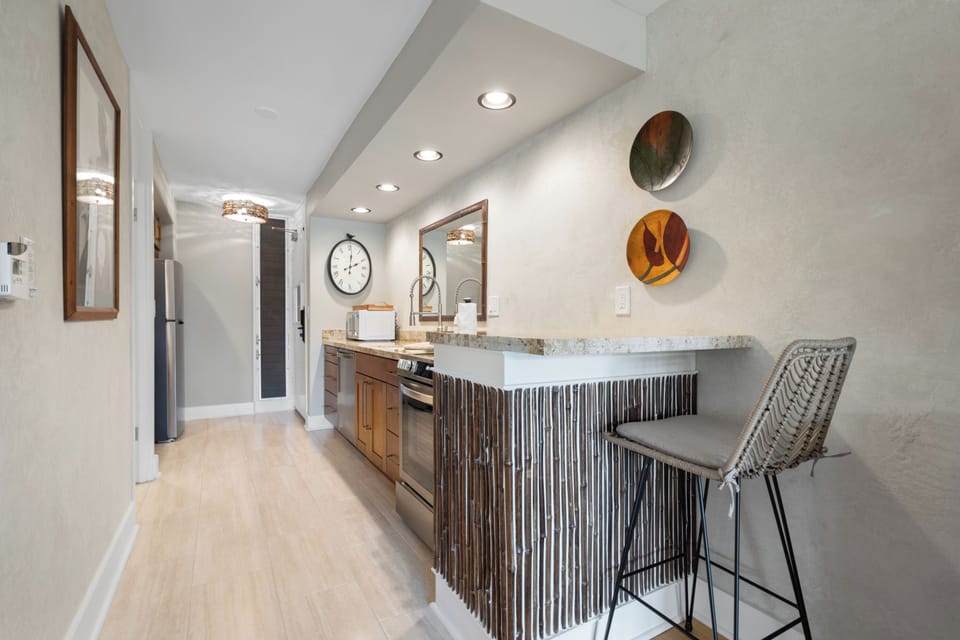 Step into your sleek kitchen, where warm wood cabinetry meets stylish marble countertops, perfect for enjoying morning coffee or whipping up a memorable meal.