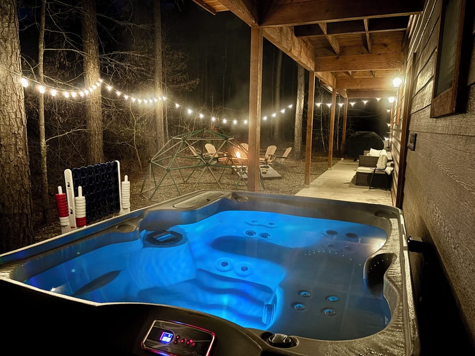 Ultimate relaxation by the hot tub and fire pit, with string lights illuminating
