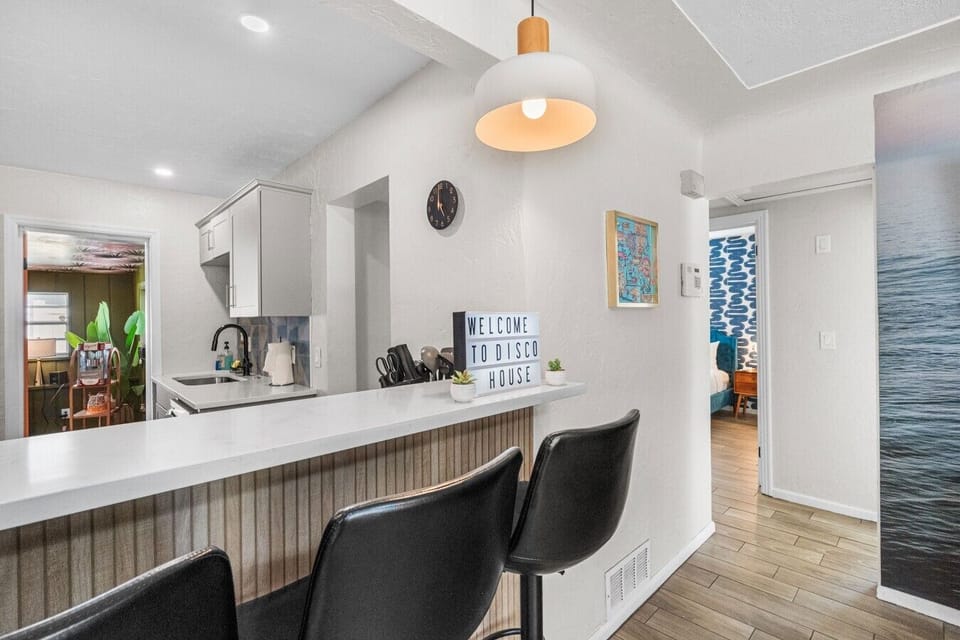 Kitchen breakfast bar with quartz countertop and bar seating. Open layout connects to living area and all 4 bedrooms. St. Petersburg, FL.