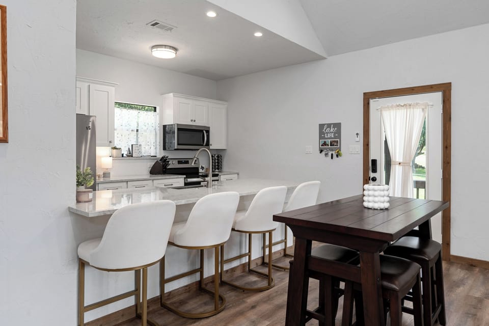 Dining area with high top table for 4 and 4 bar stools at kitchen island