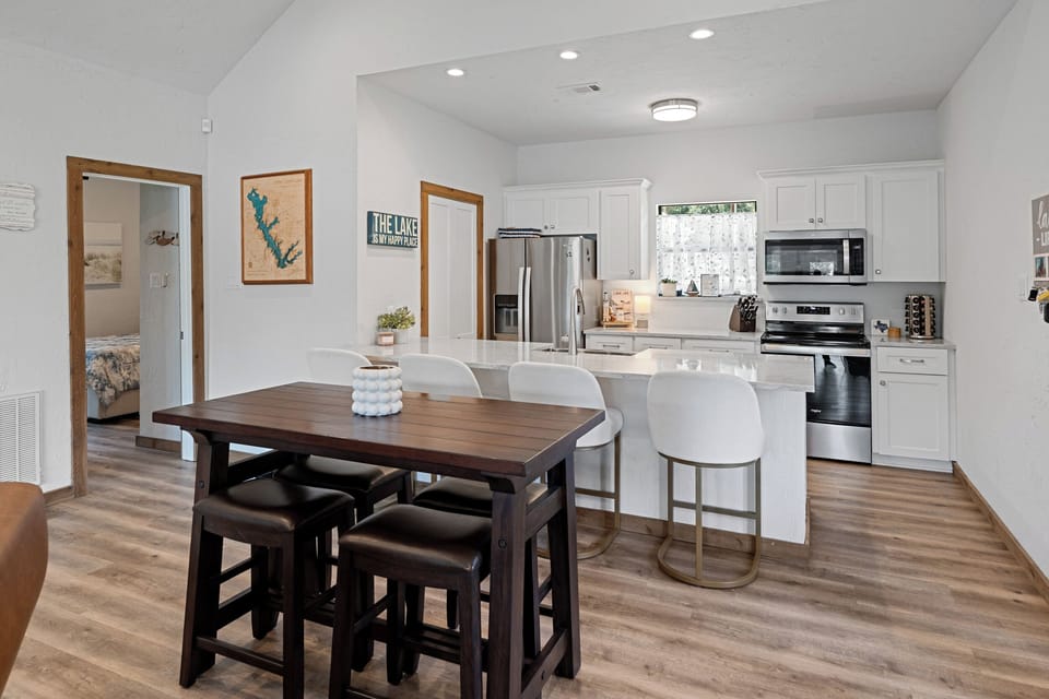 Dining area with high top table for 4 and 4 bar stools at kitchen island