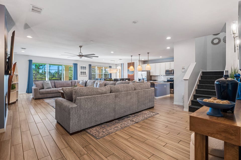 - Open living area with modern design and kitchen access  
- Orlando villa rental with large sectional and dining space  
- Family-friendly vacation home close to Disney resorts
