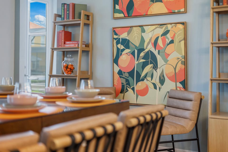 - Dining area detail with orange artwork and modern seating  
- Stylish décor highlights cheerful fruit inspired wall art  
- Cozy chairs and bright setup ideal for family gatherings