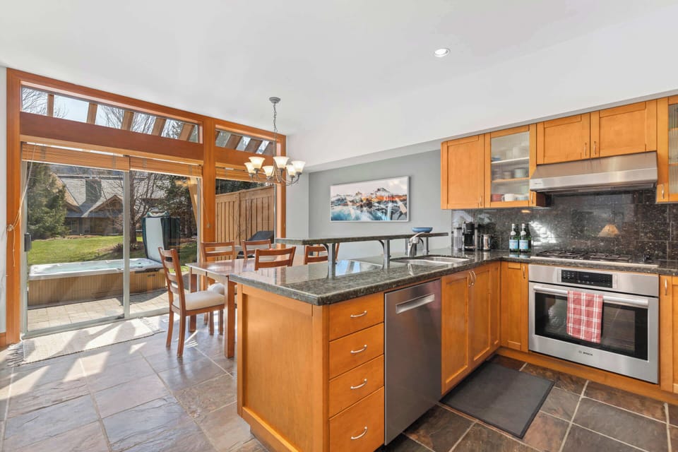 - Modern kitchen with granite countertops and light wood  
- Stainless appliances and open layout for gatherings  
- Steps from patio and bubbling outdoor hot tub 