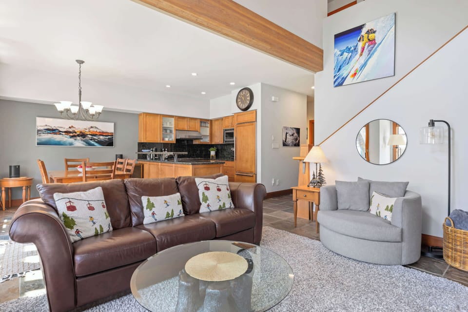 - Open living and kitchen layout with modern touches  
- Artful mountain décor and cozy seating setup  
- Perfect gathering spot after days on Whistler slopes 