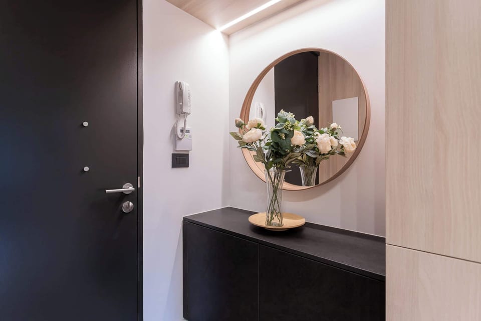 Step into a stylish entryway adorned with fresh flowers and modern design, setting the tone for your stay.