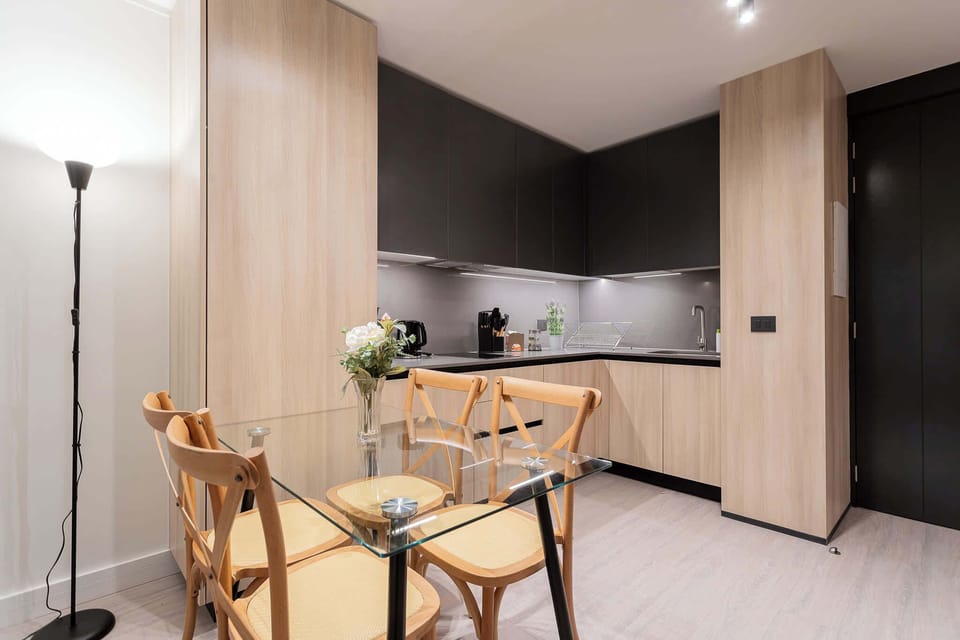 Experience modern living in this stylish kitchen, featuring sleek cabinetry and a cozy dining area perfect for meals and gatherings.