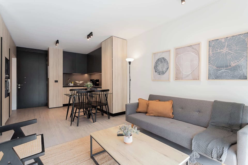 Relax in this modern living area with a cozy sofa and chic dining nook, perfect for your getaway.