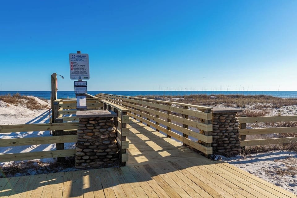 Stroll along the boardwalk leading to the serene beach, perfect for relaxation and daily beach adventures