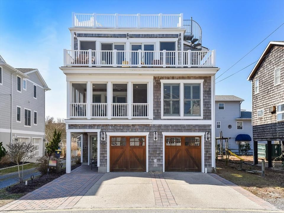 Stunning multi-level beach home with a spacious driveway and modern coastal design.