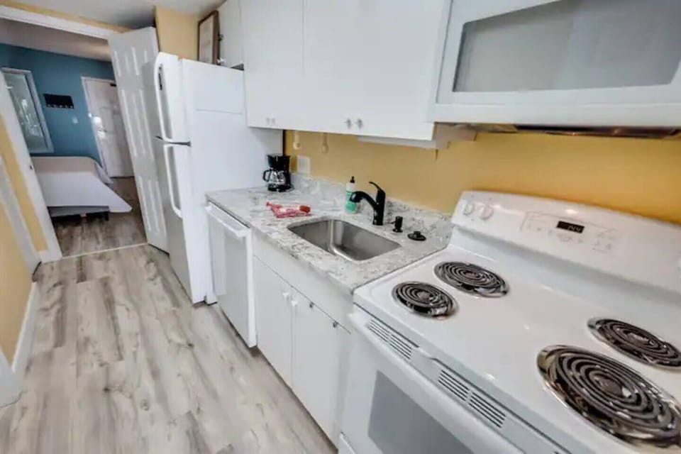 Compact kitchen w/ stove, sink & fridge, stocked with essentials for easy meals during your stay.